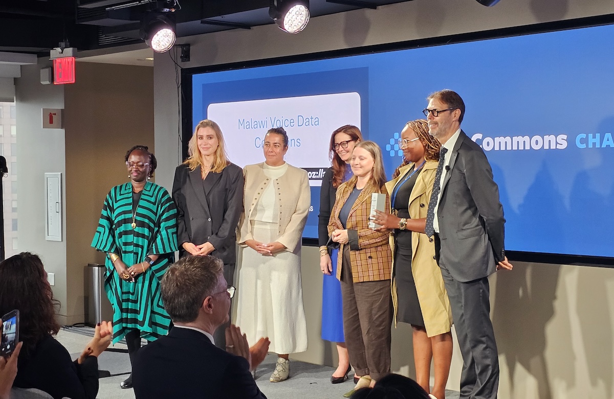 group of speakers standing in front of audience